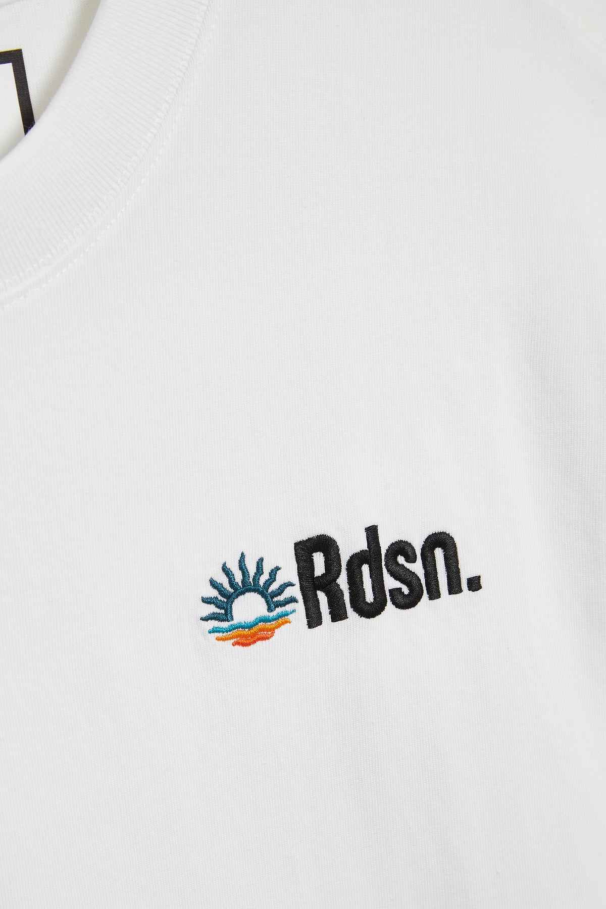 T-shirt RDSN – détail du patch brodé et du sleeve tag